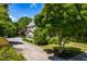 Landscaped exterior of the home featuring mature trees, gravel driveway and manicured shrubs at 2111 Woodland Ave, Raleigh, NC 27608