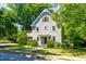 Beautiful two-story home with light gray siding, complemented by lush greenery and a neatly manicured lawn at 2111 Woodland Ave, Raleigh, NC 27608