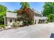Rear view of a home with gravel driveway, landscaped yard, and a screened porch at 2111 Woodland Ave, Raleigh, NC 27608