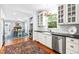 A view of the bright kitchen, featuring white cabinets, stainless steel appliances, and wood flooring at 2111 Woodland Ave, Raleigh, NC 27608