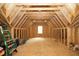 Unfinished attic space with exposed beams, a window for natural light, and wooden floors at 2200 Mays Crossroads Rd, Louisburg, NC 27549