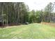 Large backyard area with mature trees and a wooden fence creating a private, serene outdoor space at 2200 Mays Crossroads Rd, Louisburg, NC 27549