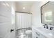 Well-lit bathroom features white vanity, modern fixtures, and a shower with a black and white curtain at 2200 Mays Crossroads Rd, Louisburg, NC 27549