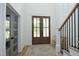 Inviting foyer with a wood-framed glass front door, wood floors, and a staircase to the side at 2200 Mays Crossroads Rd, Louisburg, NC 27549