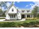 Charming two-story white farmhouse with a covered porch and well-maintained landscaping at 2200 Mays Crossroads Rd, Louisburg, NC 27549