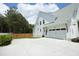 Side view of a modern white house with a two car garage and well-manicured landscaping at 2200 Mays Crossroads Rd, Louisburg, NC 27549