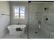 Modern bathroom with a freestanding tub and glass enclosed shower, plus window view at 25 Deer Tail Ln # 52, Fuquay Varina, NC 27526