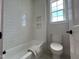 Well-lit bathroom features a tub with white subway tile and a built-in shelving unit at 25 Deer Tail Ln # 52, Fuquay Varina, NC 27526