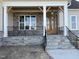 Inviting front porch featuring stone accents, black railing, and wood pillars for a modern, stylish entrance at 25 Deer Tail Ln # 52, Fuquay Varina, NC 27526