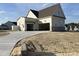 Spacious three-car garage with concrete driveway and stone accents on an attractive new construction home at 25 Deer Tail Ln # 52, Fuquay Varina, NC 27526