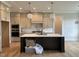 Spacious kitchen with a large dark island, light grey cabinets, and modern lighting fixtures at 25 Deer Tail Ln # 52, Fuquay Varina, NC 27526