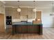 A modern kitchen features stainless steel appliances, an island with a dark finish, and stylish light fixtures at 25 Deer Tail Ln # 52, Fuquay Varina, NC 27526