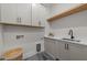 Well-organized laundry room with modern cabinetry, countertop, sink, and stylish flooring at 25 Deer Tail Ln # 52, Fuquay Varina, NC 27526