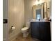 Neutral powder room with shiplap walls, wood floors, and a black vanity at 25 Deer Tail Ln # 52, Fuquay Varina, NC 27526