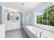 Bathroom with double sink vanity, soaking tub and shower with white subway tile at 2506 Blooming St, Raleigh, NC 27612
