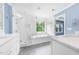 Bathroom featuring double sinks, a walk-in shower, and a soaking tub with a window at 2506 Blooming St, Raleigh, NC 27612