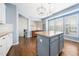 Kitchen with light blue walls, white cabinets, an island, and stainless steel appliances at 2506 Blooming St, Raleigh, NC 27612