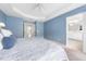 Bedroom featuring a tray ceiling and an open ensuite bathroom at 2506 Blooming St, Raleigh, NC 27612