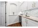 Stylish wet bar featuring granite countertops, a wine fridge, and white cabinets at 2506 Blooming St, Raleigh, NC 27612