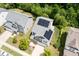 Aerial view of a two-story home with a gray roof and solar panels surrounded by a green lawn and mature trees at 2513 Magnolia Tree Ln, Durham, NC 27703