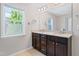 Bathroom showcasing double vanity with granite countertop, dark wood cabinetry, and a large mirror at 2513 Magnolia Tree Ln, Durham, NC 27703