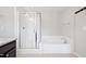Bright bathroom featuring a glass-enclosed shower and separate soaking tub at 2513 Magnolia Tree Ln, Durham, NC 27703