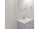 Modern bathroom featuring a gray vanity cabinet, oval mirror, and contemporary faucet at 2513 Magnolia Tree Ln, Durham, NC 27703