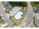 Aerial view of the community pool with a playground, parking, and lounging area surrounded by sidewalks and roads at 2513 Magnolia Tree Ln, Durham, NC 27703