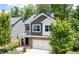 A two-story home with stone accents, a two-car garage, solar panels and is surrounded by mature trees at 2513 Magnolia Tree Ln, Durham, NC 27703