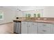 Modern kitchen boasts stainless steel appliances, granite countertops, and white cabinetry that opens to a living space at 2513 Magnolia Tree Ln, Durham, NC 27703