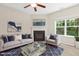 Cozy living room with fireplace, ceiling fan, plush rug, and lots of natural light at 2513 Magnolia Tree Ln, Durham, NC 27703