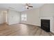 Bright living room with a cozy fireplace, ceiling fan, and wood-look flooring throughout at 2513 Magnolia Tree Ln, Durham, NC 27703