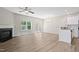 Bright living room with a cozy fireplace opens to the kitchen, featuring wood-look flooring throughout at 2513 Magnolia Tree Ln, Durham, NC 27703