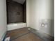 Modern bathroom featuring a new white tub with gray tiled walls at 269 Deer Tail Ln # 44, Fuquay Varina, NC 27526