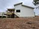 Exterior shot of a white home featuring a rear wooden deck and stairs, complemented by modern architecture at 269 Deer Tail Ln # 44, Fuquay Varina, NC 27526