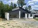 Modern home with a black metal roof, white brick accents, and large windows offering natural light at 269 Deer Tail Ln # 44, Fuquay Varina, NC 27526