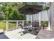 Outdoor patio with table and chairs, a black umbrella, grill and white lattice at 2833 Praire View Pt, Wendell, NC 27591