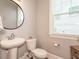 Clean bathroom features a pedestal sink, toilet, and a mirror at 2909 Thurman Dairy Loop, Wake Forest, NC 27587