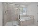 Bathroom featuring glass shower, a bathtub, and a window providing natural light at 333 Trout Valley Rd, Wake Forest, NC 27587