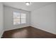 A simple, well-lit bedroom featuring a window and dark, laminate flooring at 333 Trout Valley Rd, Wake Forest, NC 27587