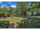 Large backyard with mature trees, lawn, and deck at 345 Kinsman Ct, Fuquay Varina, NC 27526