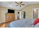 Spacious bedroom boasts a large TV, wooden dresser and hardwood floors at 345 Kinsman Ct, Fuquay Varina, NC 27526