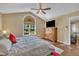 Bedroom with vaulted ceiling, large arched window, and wooden dresser with TV at 345 Kinsman Ct, Fuquay Varina, NC 27526