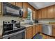 A well-lit kitchen with stainless steel appliances, wood cabinets, and hardwood floors at 345 Kinsman Ct, Fuquay Varina, NC 27526