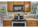 Well lit kitchen featuring stainless steel appliances, wood cabinets and a stone patterned countertop at 345 Kinsman Ct, Fuquay Varina, NC 27526