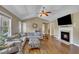 Bright living room featuring a fireplace, hardwood floors, and large windows for natural light at 345 Kinsman Ct, Fuquay Varina, NC 27526