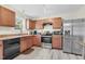 Features stainless steel appliances and wood cabinets against the light wood floors at 4108 Lady Slipper Ln, Durham, NC 27704