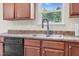 Kitchen sink features a window overlooking green trees, a modern faucet, and wood cabinets at 4108 Lady Slipper Ln, Durham, NC 27704