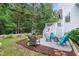 Landscaped backyard featuring a seating area with Adirondack chairs and a fire pit at 429 Marsh Landing Dr, Holly Springs, NC 27540
