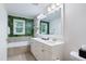 Luxurious bathroom with a double vanity, soaking tub, and natural light at 429 Marsh Landing Dr, Holly Springs, NC 27540